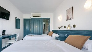 A hotel room with two beds, a desk, a chair, a TV, and a painting on the wall. - Hotel Agur (Fuengirola)