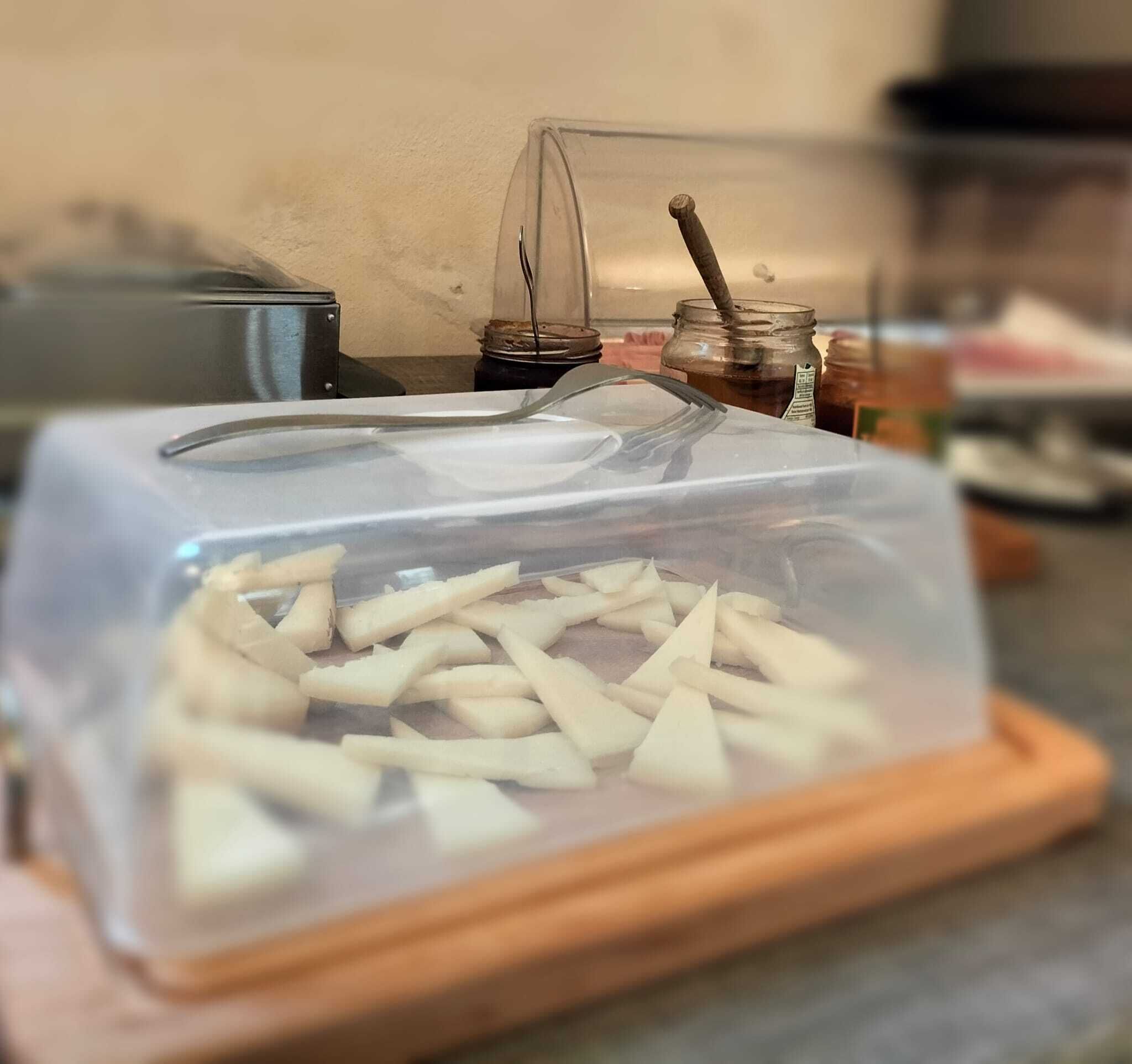A food storage container with a transparent lid, placed on a wooden board.
