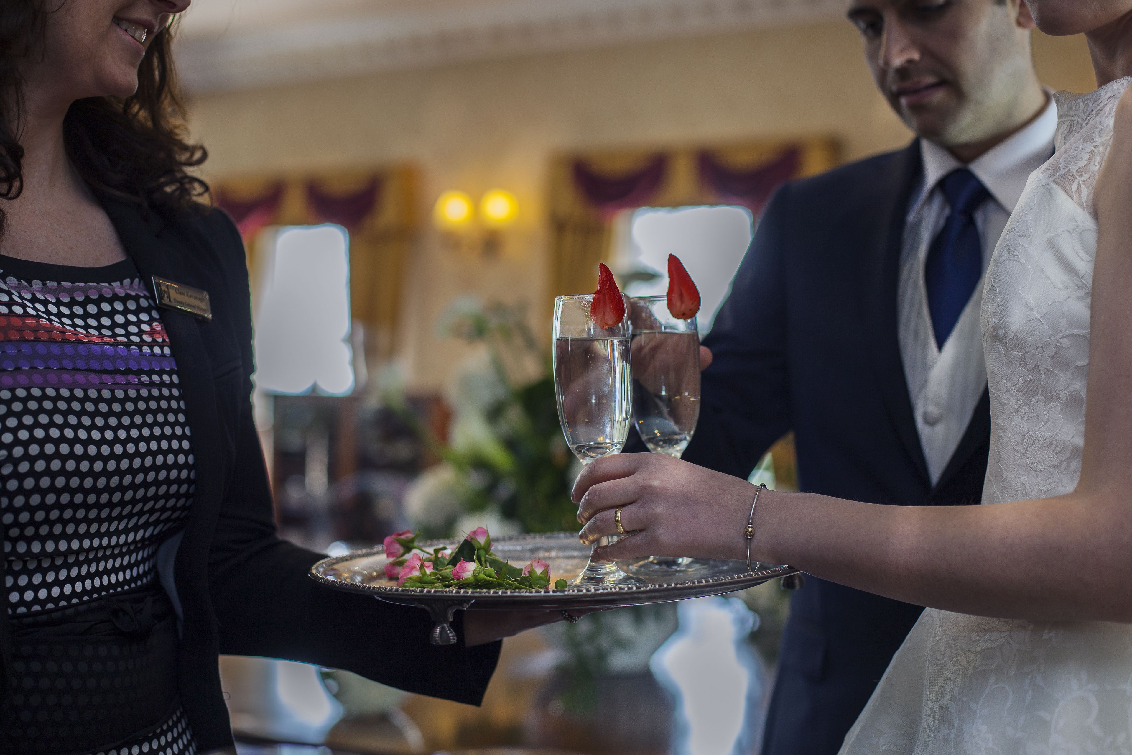 A wedding reception with a glass of water and a strawberry garnish on a tray.