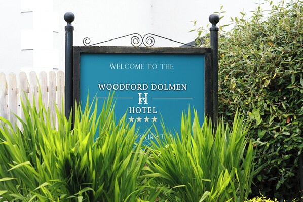 A sign for the Woodford Dolmen Hotel with a welcoming message and a star rating. - Woodford Dolmen Hotel (Carlow)