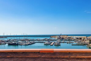 A marina with boats docked, a clear sky, and a distant shoreline. - Hotel Aliai (Sciacca)