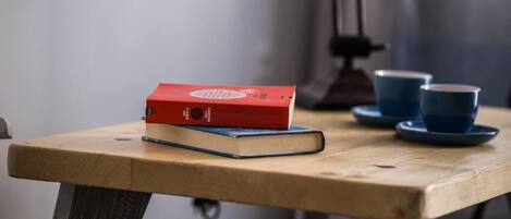 Un tavolo in legno con due libri e due tazze blu su piattini.