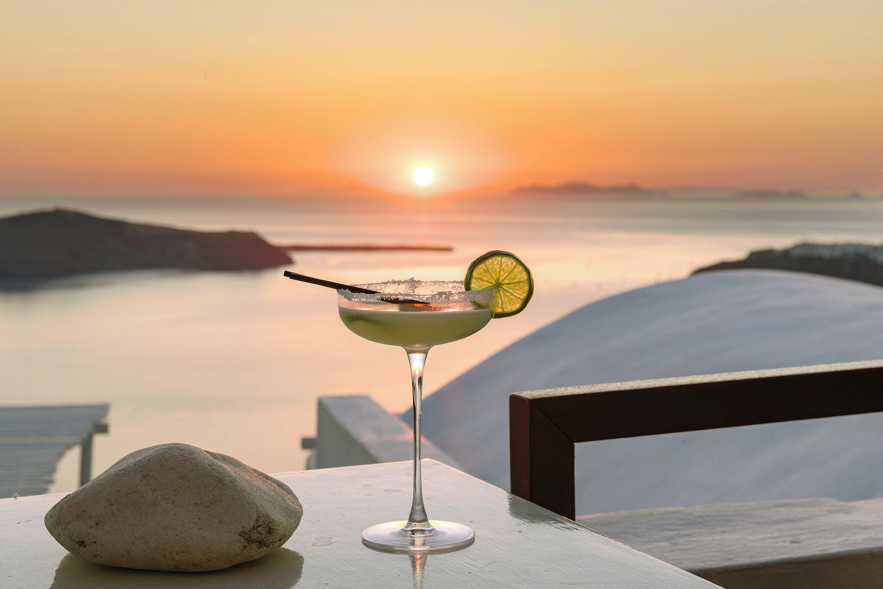 A sunset view with a cocktail on a table.