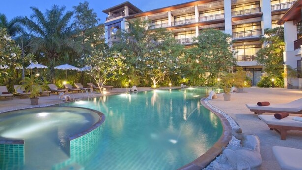 A pool area with lounge chairs and a building in the background. - Le Murraya Boutique Hotel (Koh Samui)