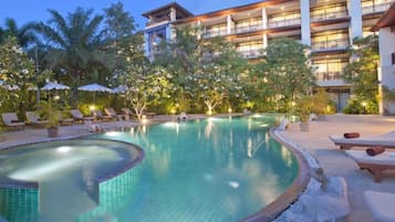 Una piscina al aire libre, sillones reclinables de piscina