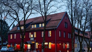 A red building with multiple windows and a sloped roof, likely a hotel or restaurant. - Hotel Zum Harzer (Clausthal-Zellerfeld)