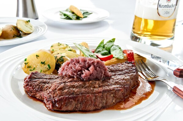 A plate with a steak, potatoes, and a side salad. - Hotel Zum Harzer (Clausthal-Zellerfeld)