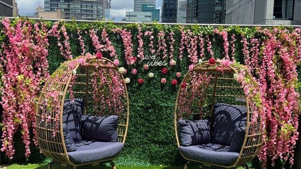 Two wicker chairs with cushions against a backdrop of pink flowers and greenery. - Fairfield Inn & Suites by Marriott New York ManhattanChelsea (New York)
