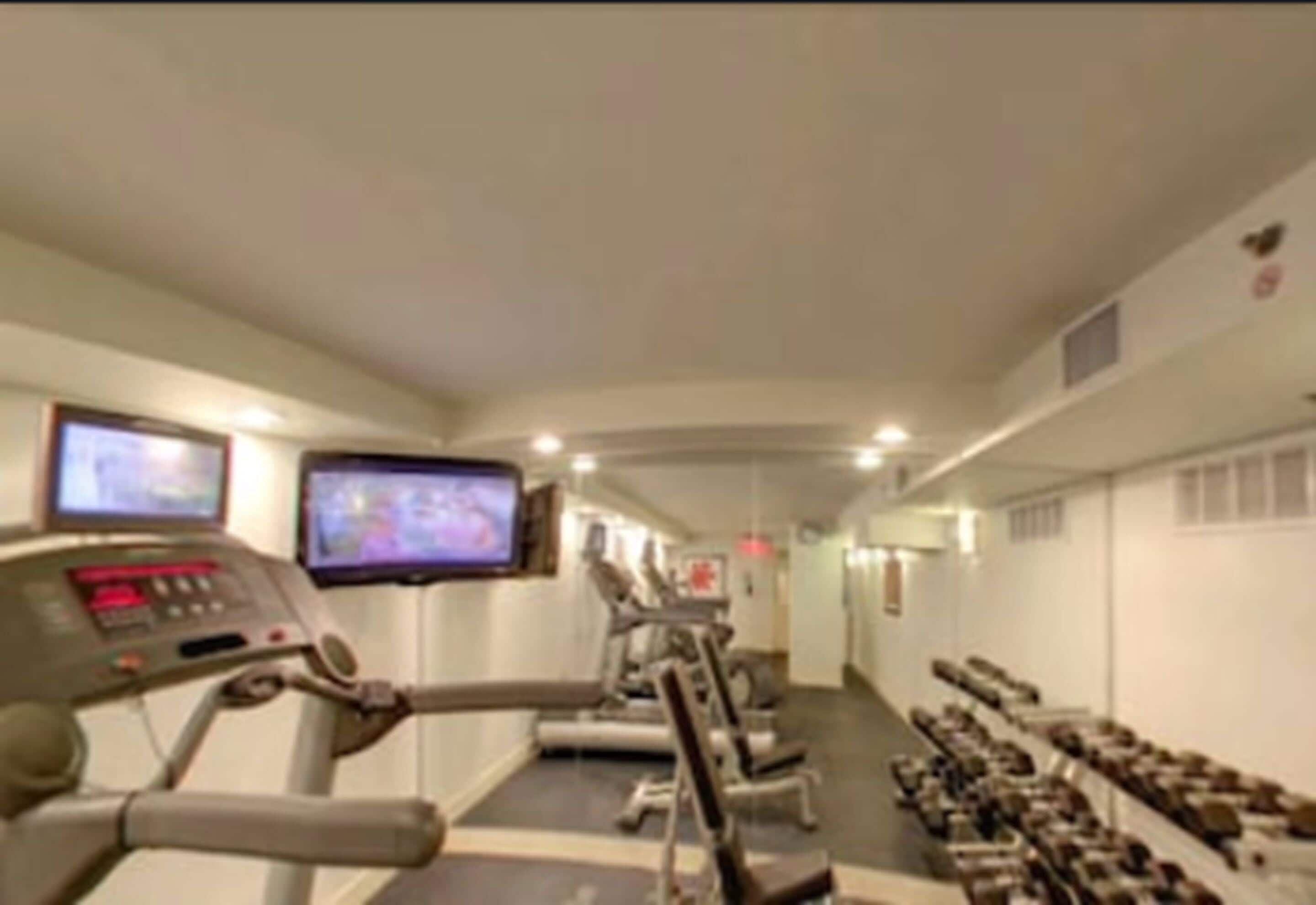 A gym with treadmills, stationary bikes, and weight machines.