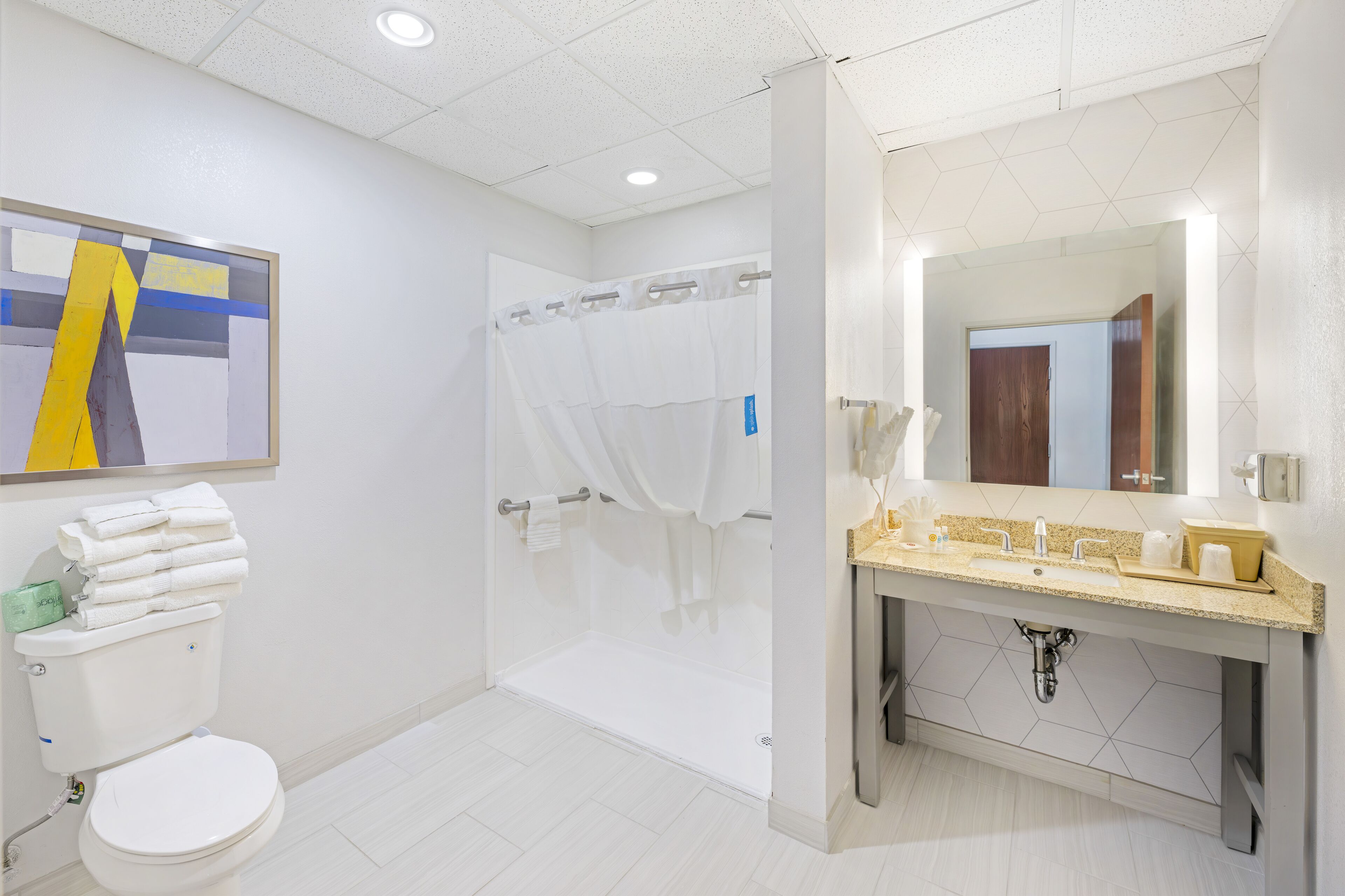A modern bathroom with a toilet, shower, and sink area.