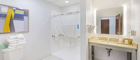 A modern bathroom with a toilet, shower, and sink area.