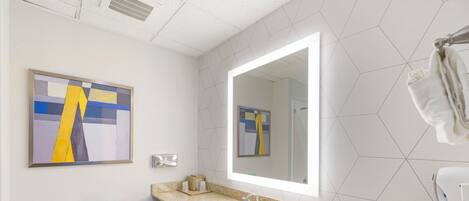 Un baño moderno con inodoro, lavamanos y espejo.