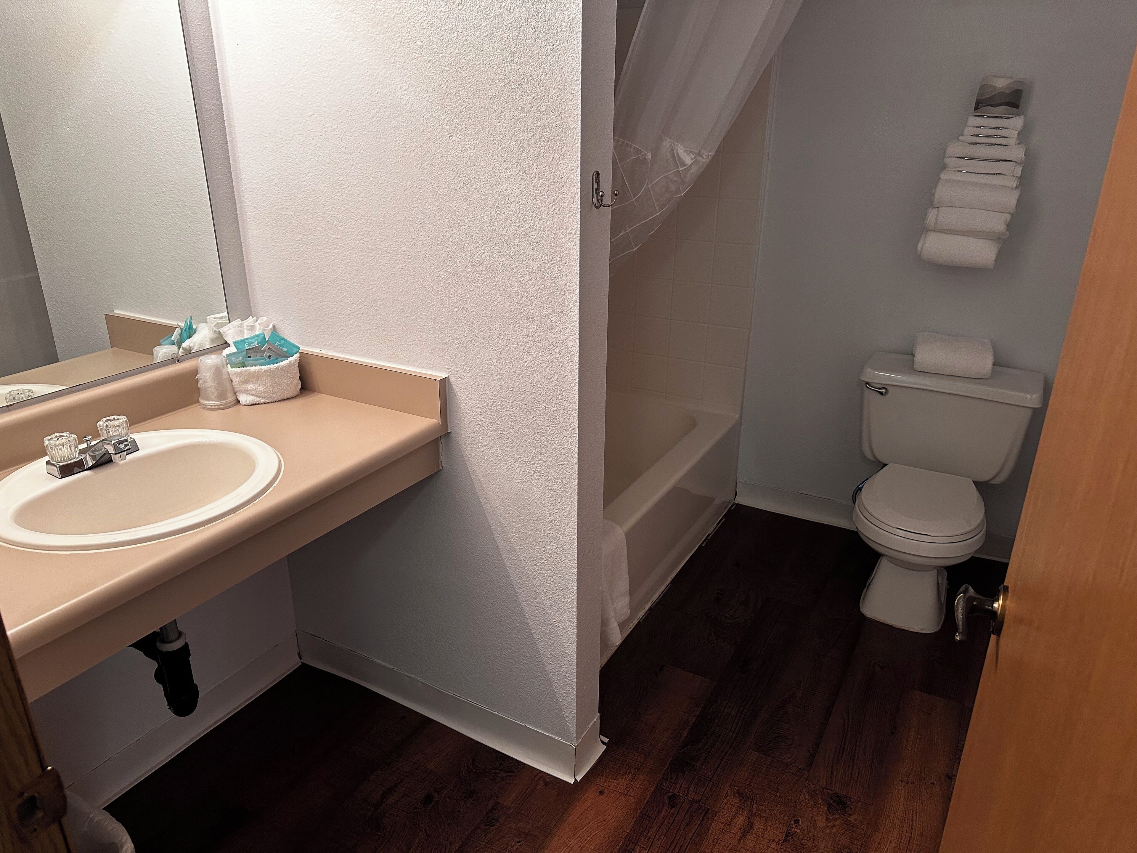 Un baño con lavamanos, espejo, inodoro y zona de ducha.