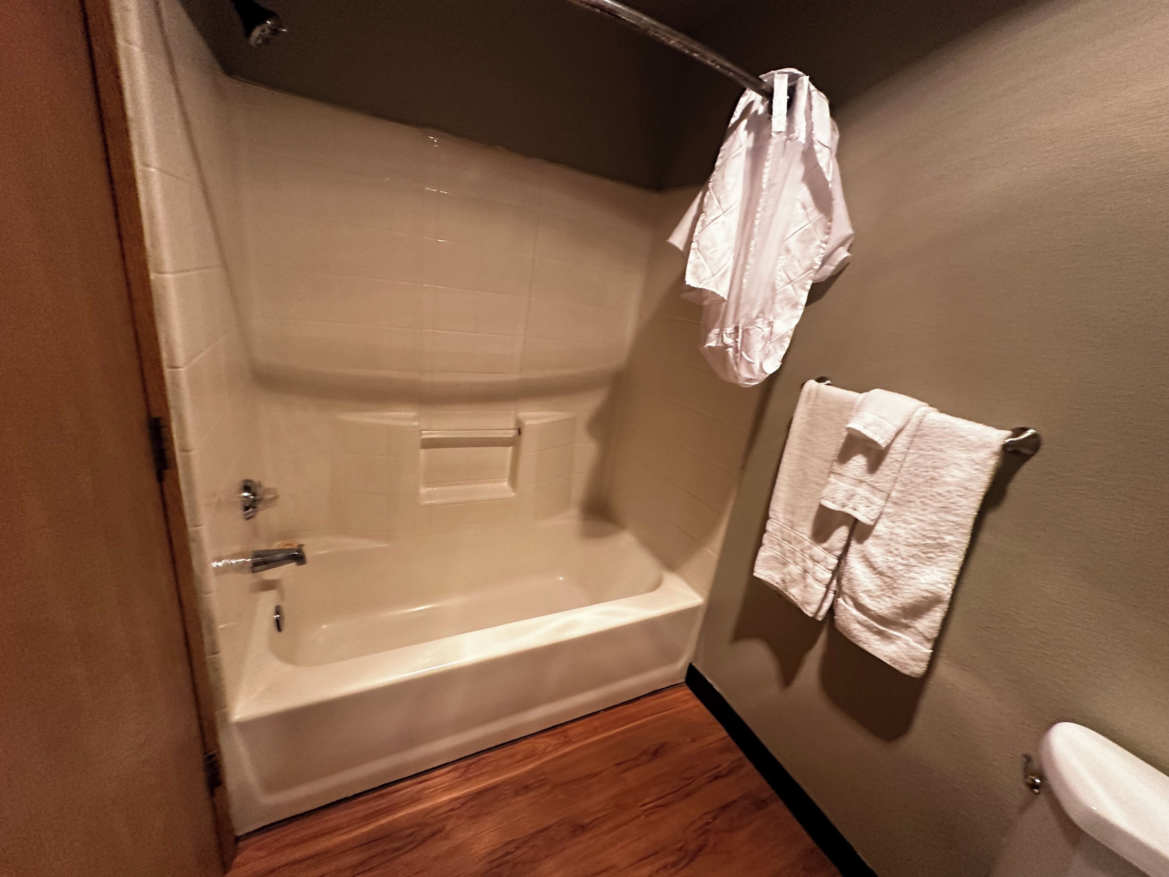 A bathroom with a bathtub, a towel rack, and a toilet.