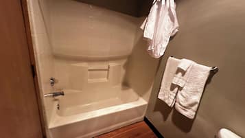 A bathroom with a bathtub, a towel rack, and a toilet.