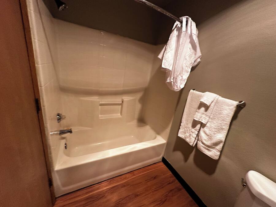 A bathroom with a bathtub, a towel rack, and a toilet.