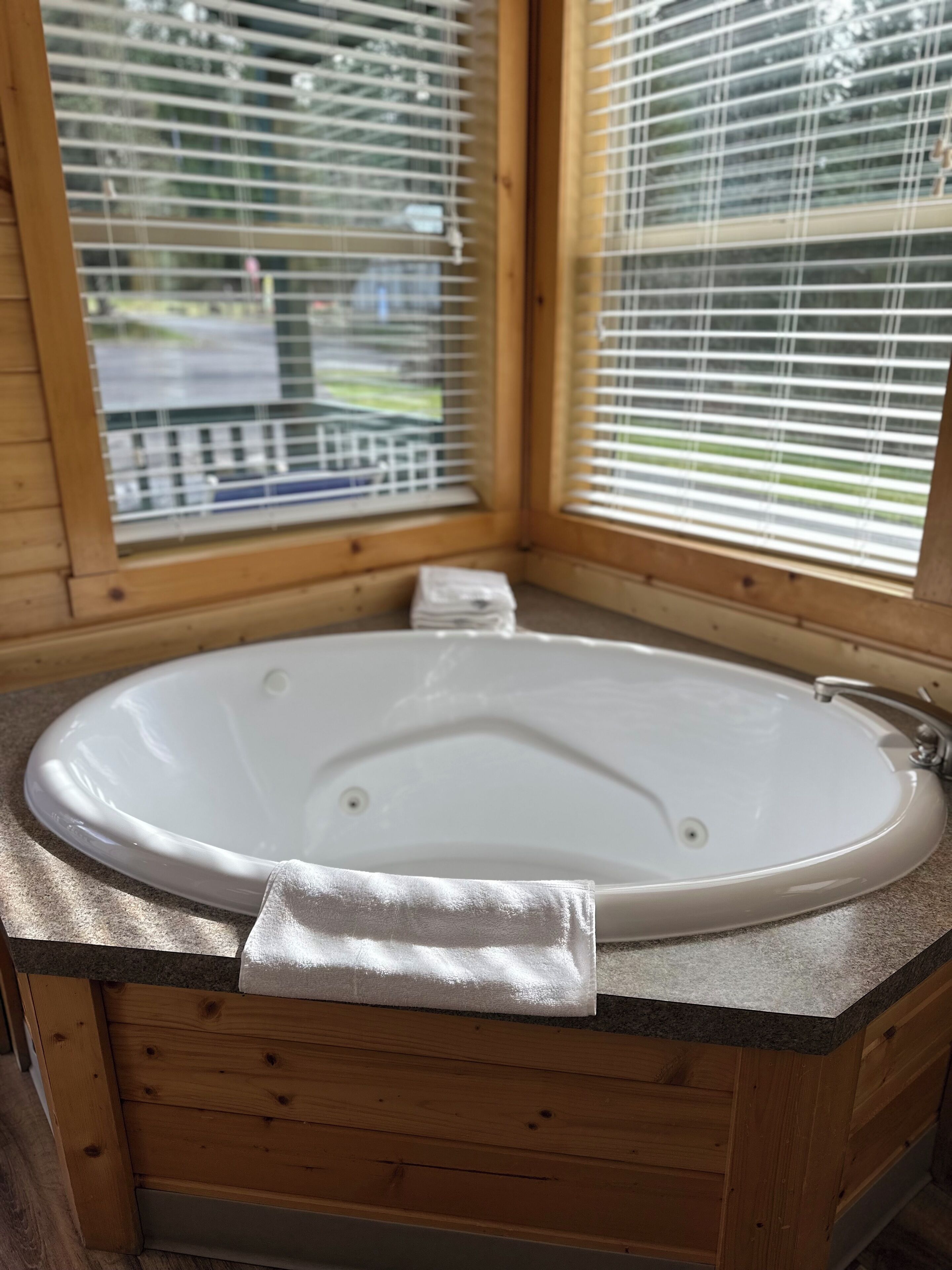 Una cabaña de madera con un jacuzzi ovalado grande.