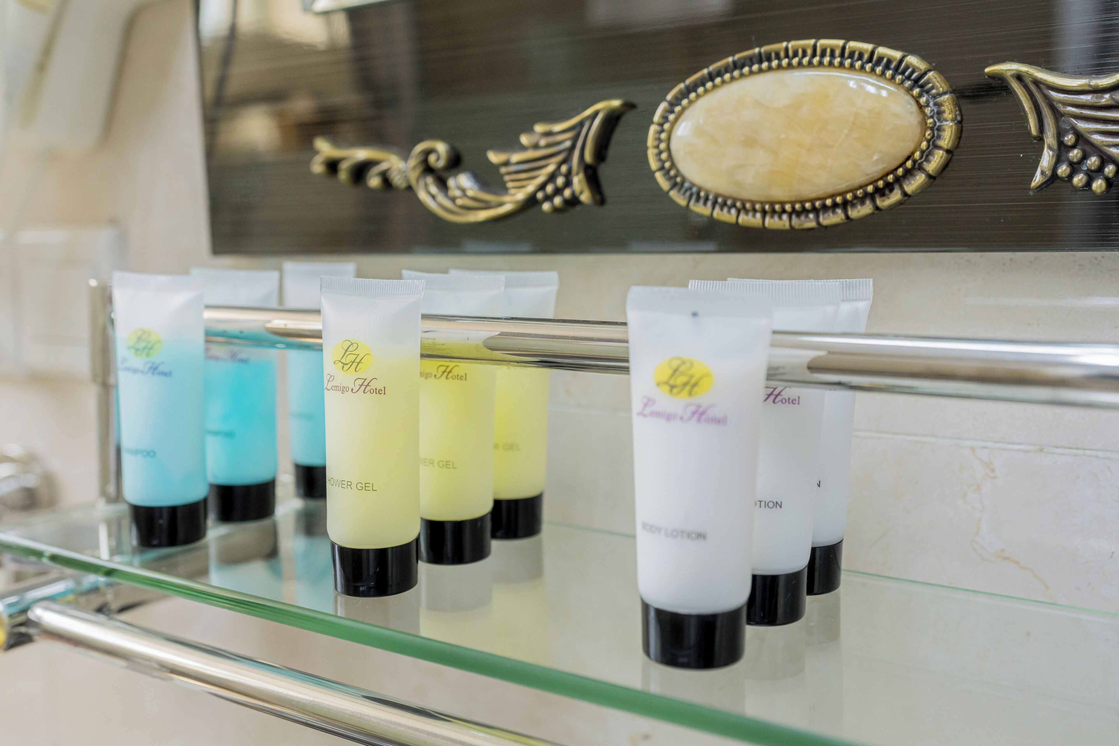 A display of hotel toiletries on a glass shelf.