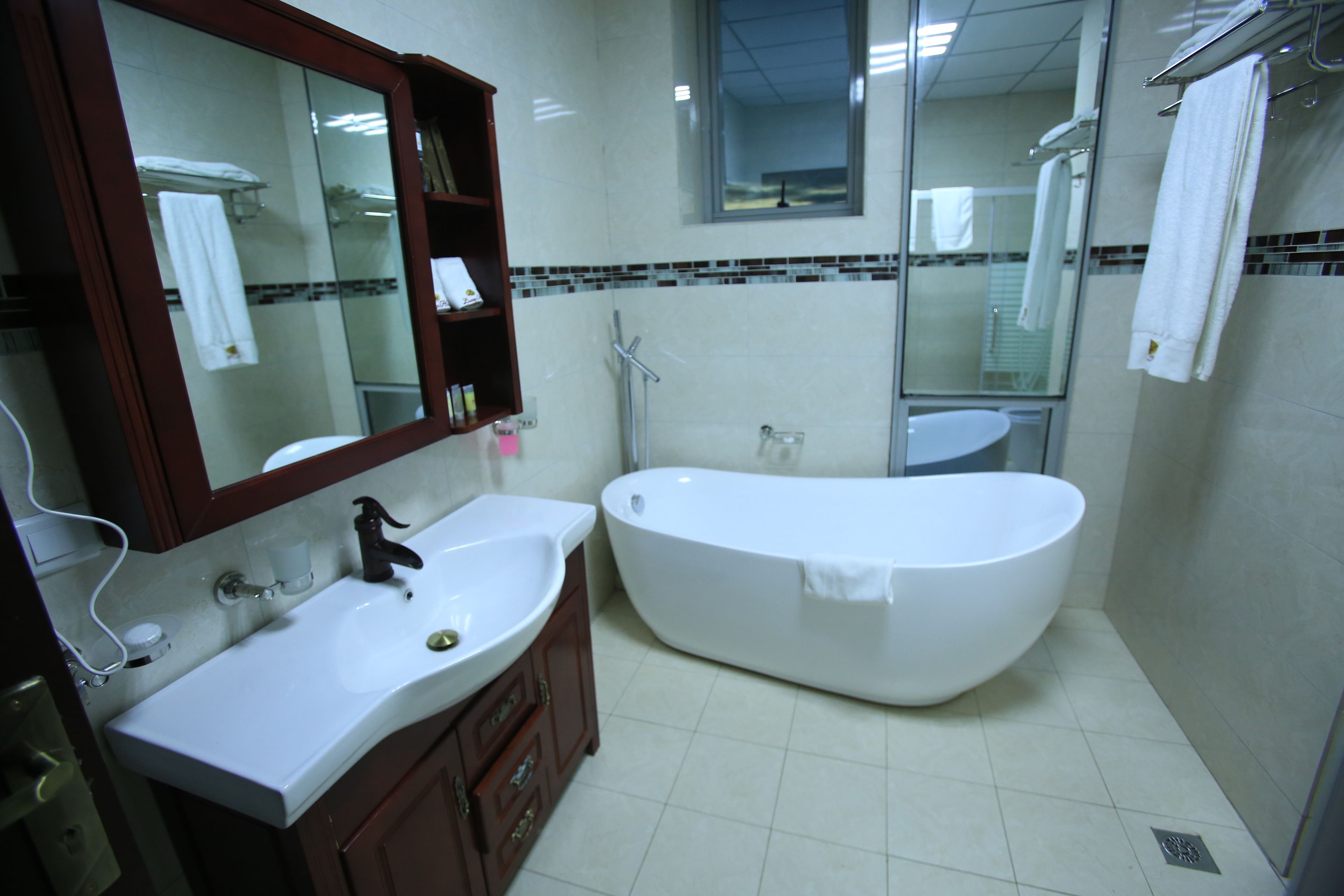 Un baño con un lavamanos blanco, una bañera y un espejo.