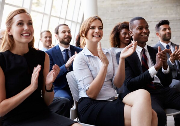 Un grupo de personas sentadas en una sala de reuniones con amplios ventanales, lo que sugiere un ambiente profesional.