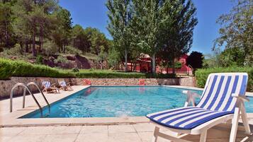 Una piscina al aire libre, tumbonas
