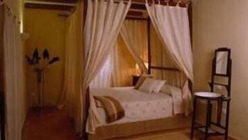 Un dormitorio con una cama, una silla y una mesita de noche.