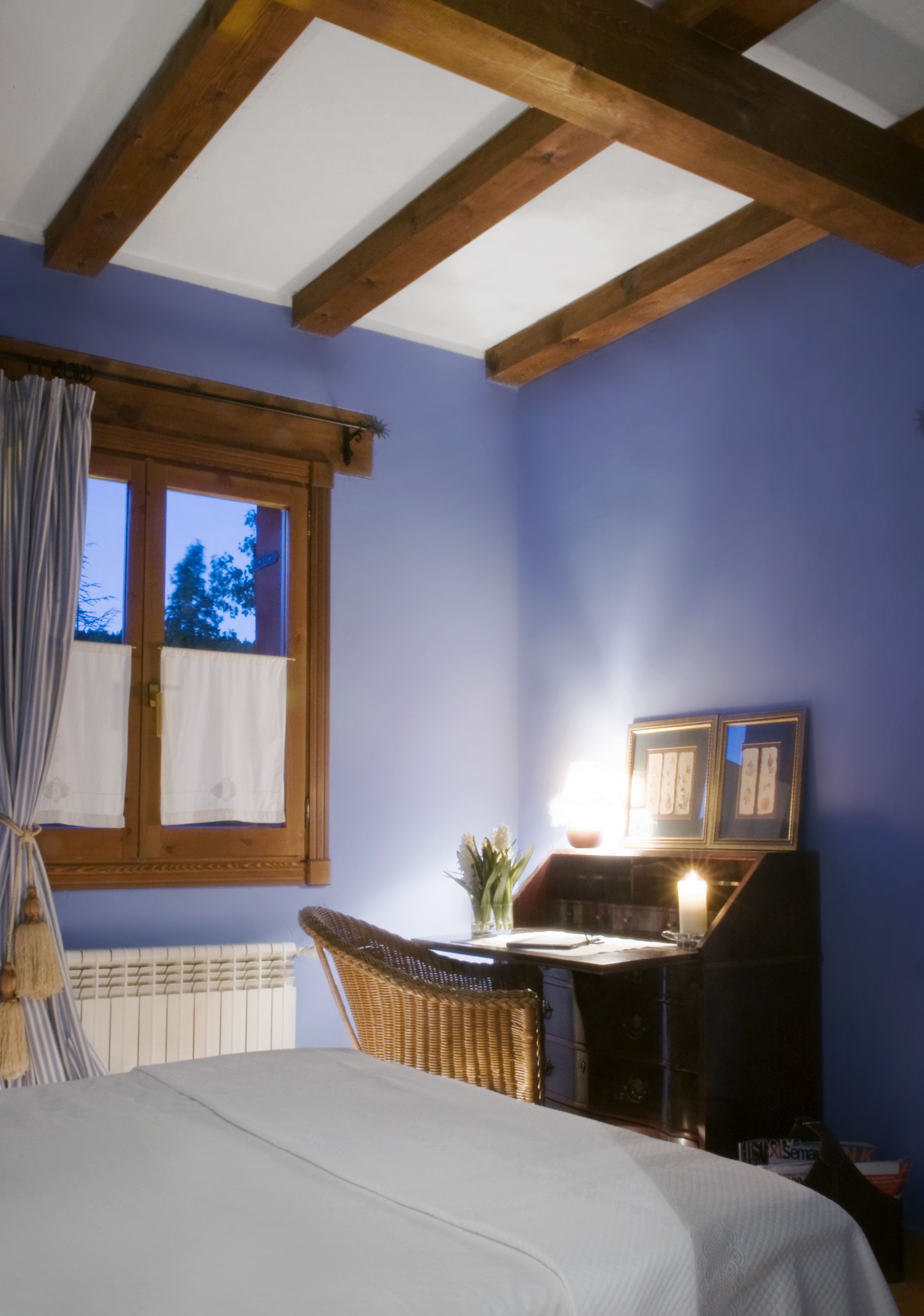 Una camera da letto con un letto, una scrivania e una finestra con tende.