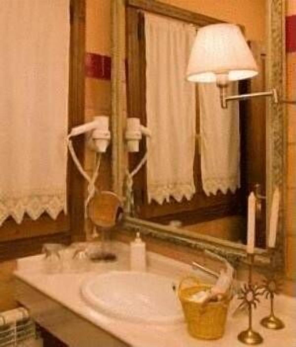 Un bagno con lavandino, specchio, asciugamano e lampada.