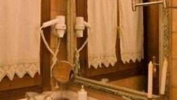 Un bagno con lavandino, specchio, asciugamano e lampada.