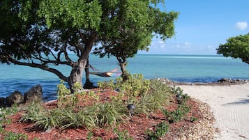 Aan een privéstrand, ligstoelen, strandlakens, kajakken