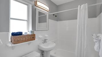 A modern bathroom with a bathtub, a sink, and a shower.