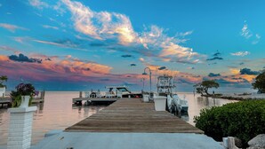A wooden pier leading to a dock with boats, a clear sky, and calm water. - Seascape Resort & Marina (Marathon)