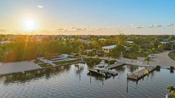 A marina with boats docked, a swimming pool, and a well-maintained landscape with trees and pathways.