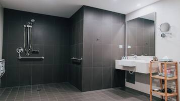 Un bagno moderno con cabina doccia, lavandino e specchio.