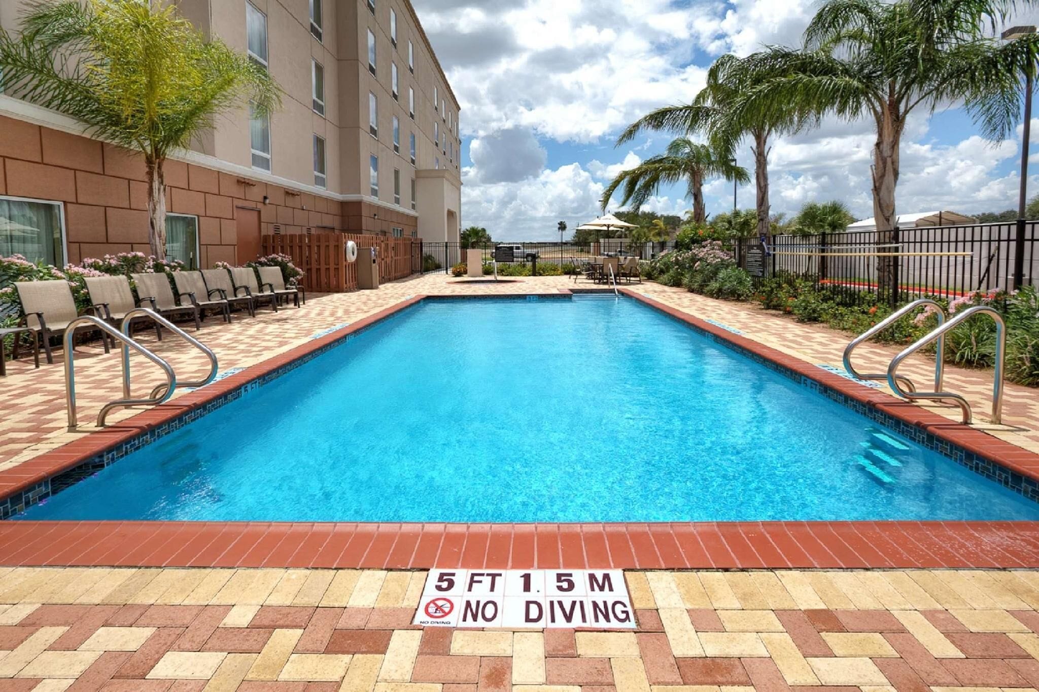 Una piscina al aire libre, sillones reclinables de piscina