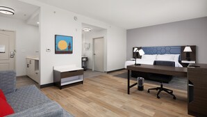 Ein modernes Hotelzimmer mit Bett, Schreibtisch und Sitzecke.