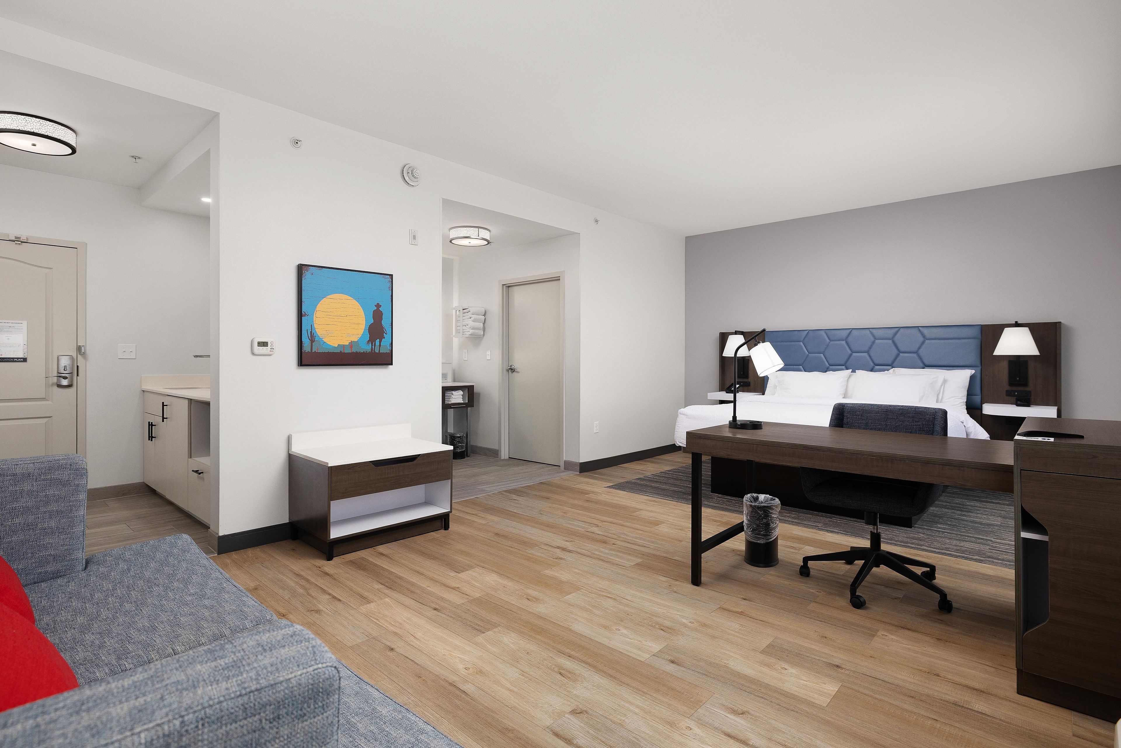 Ein modernes Hotelzimmer mit Bett, Schreibtisch und Sitzecke.