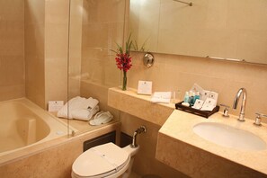 A modern bathroom with a bathtub, toilet, and sink. - Blue Suites Hotel (Bogotá)