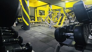 Ein Fitnessstudio mit verschiedenen Trainingsgeräten, darunter Kurzhanteln und Kraftgeräte.