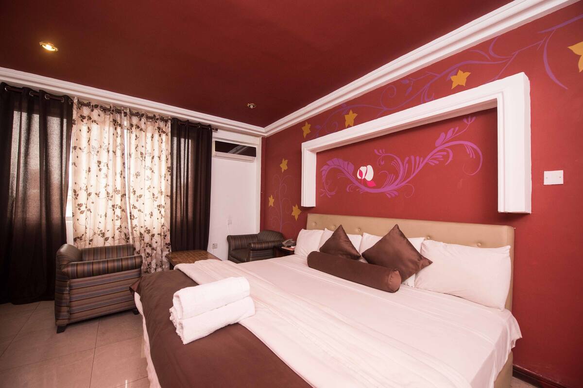 Habitación de hotel con una cama grande, un sofá y un zócalo decorativo.