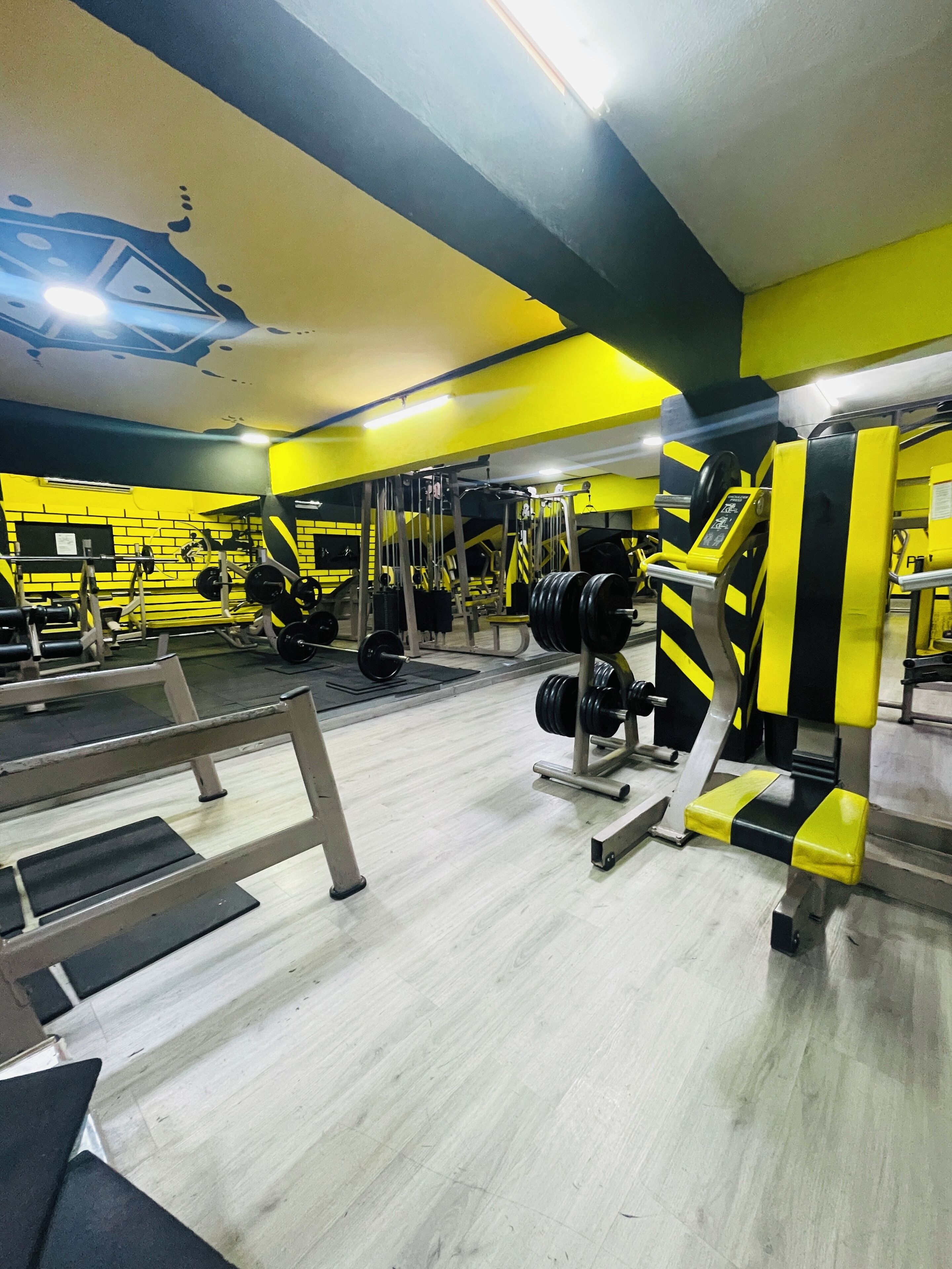 Un gimnasio con diversos equipos de ejercicio, incluyendo máquinas de pesas y pesas libres.