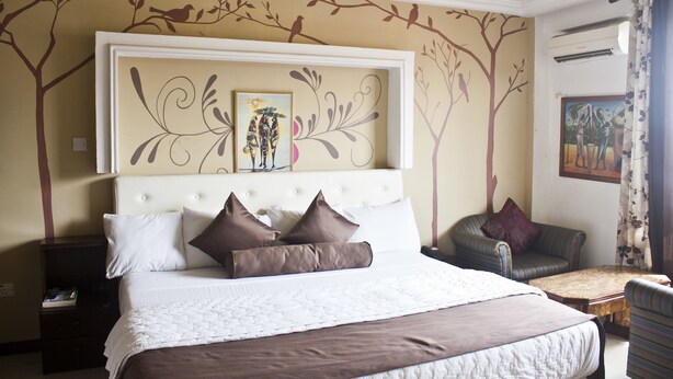 Ein aufgeräumtes Schlafzimmer mit einem großen Bett, einem Sofa und einem kleinen Tisch.