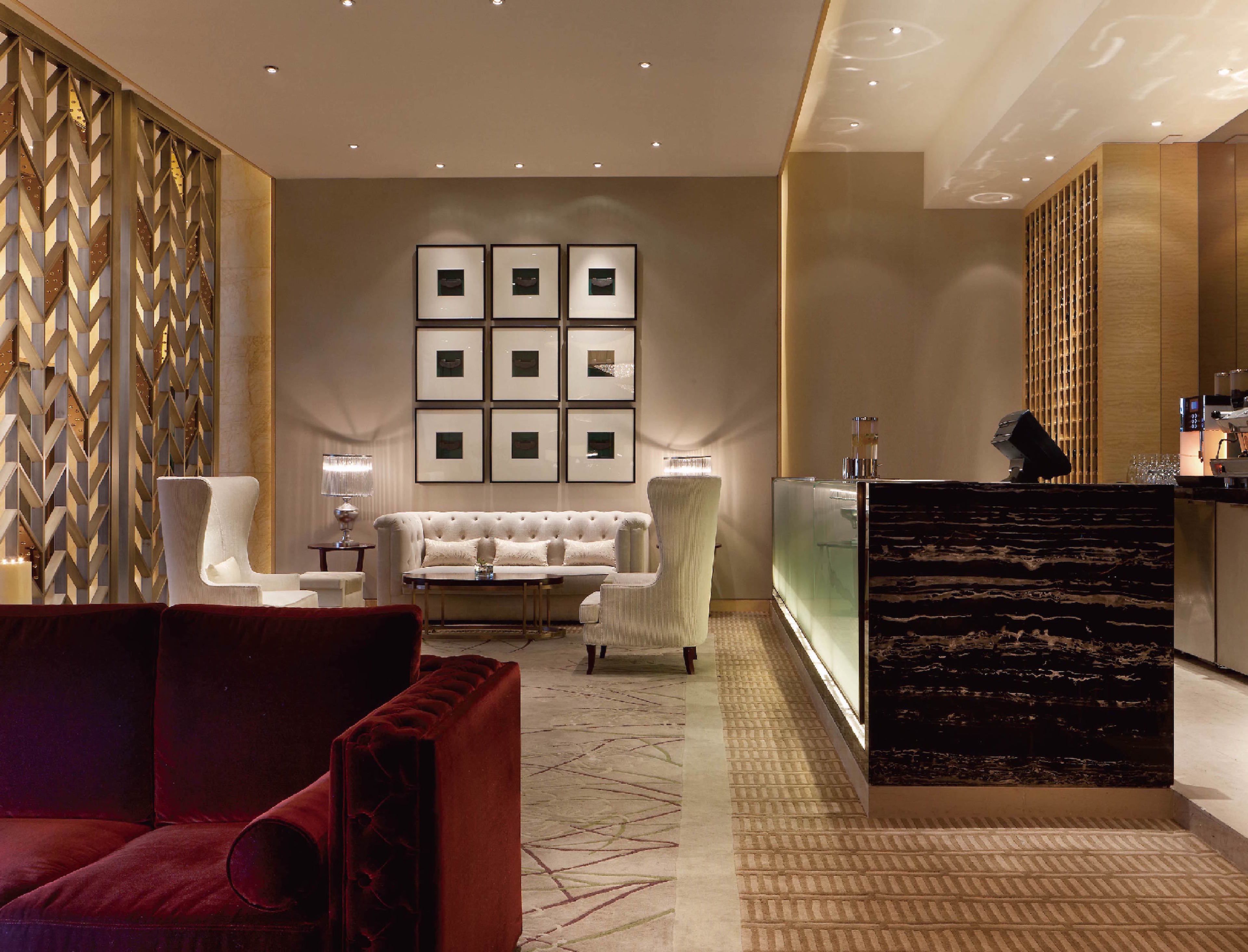 A modern lobby with a white sofa, red armchair, and a reception desk.