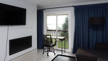 Estudio Premium, 1 cama King size y sofá cama, chimenea, vista al lago | Área de sala de estar | Televisión LCD de 42 pulgadas con canales premium y televisión