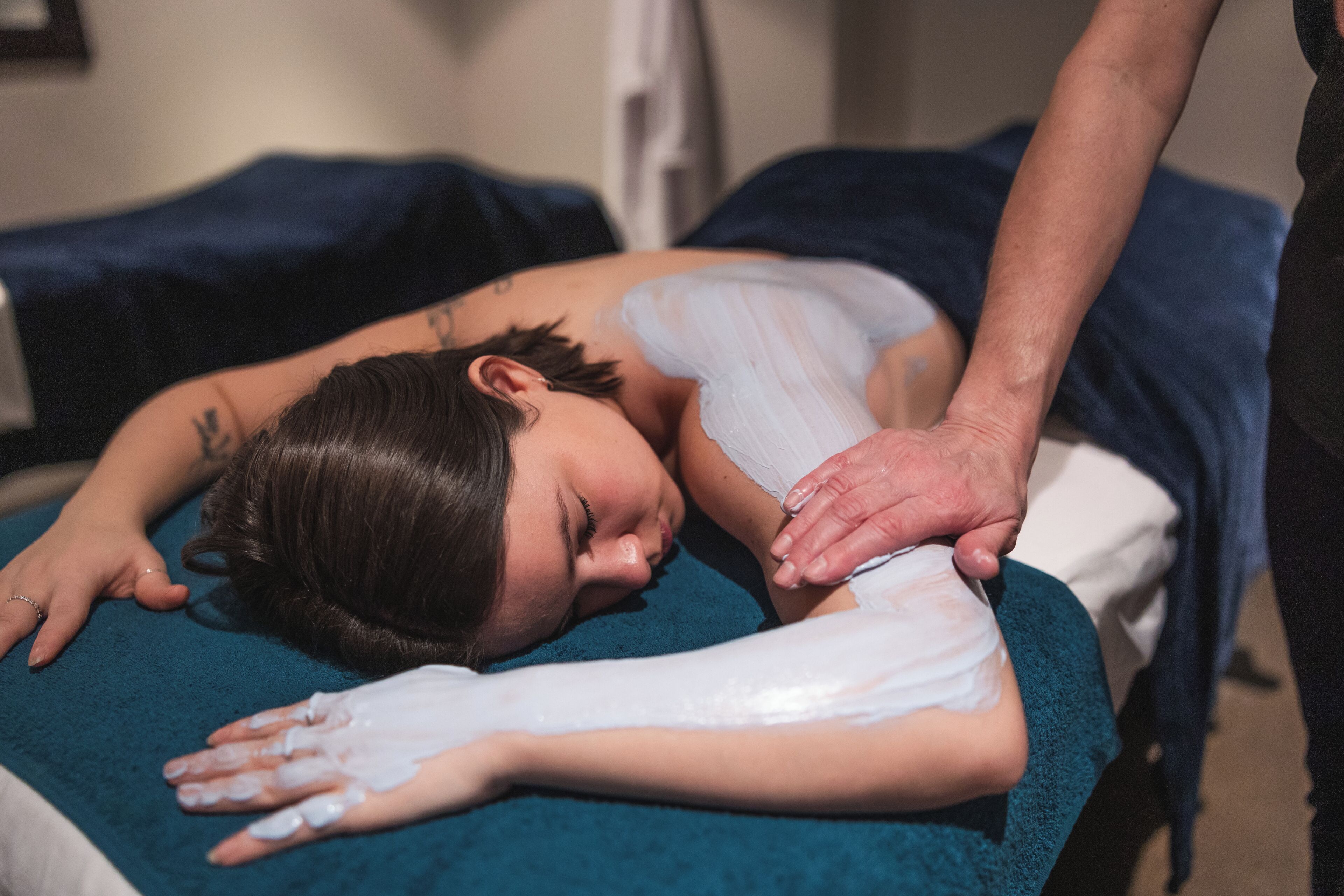Een persoon ligt op een massagetafel en ontvangt een behandeling.