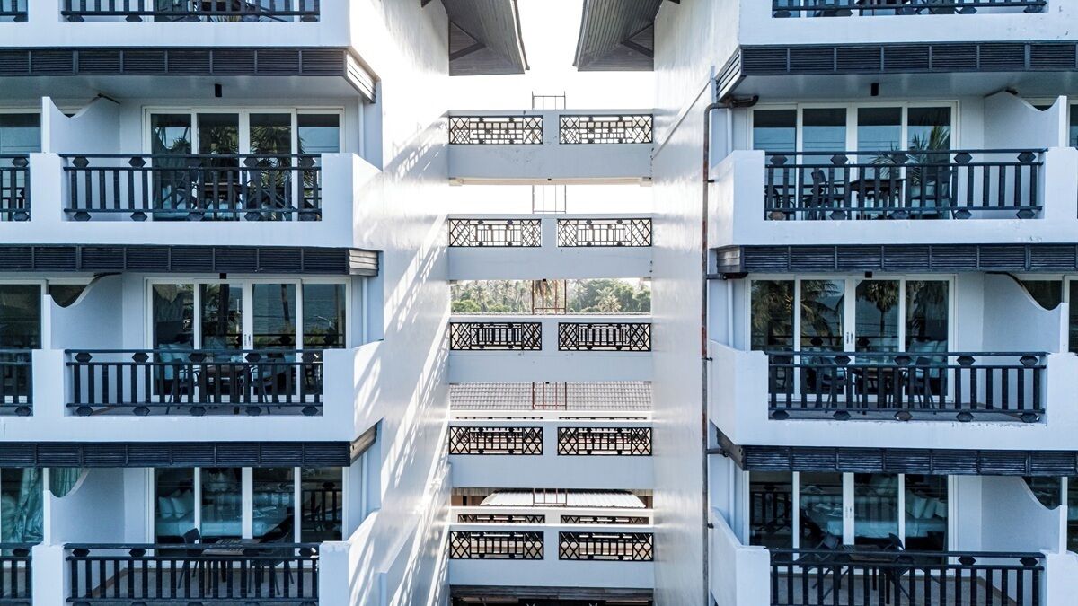 Um edifício com várias andares, varandas, grandes janelas e um átrio central.