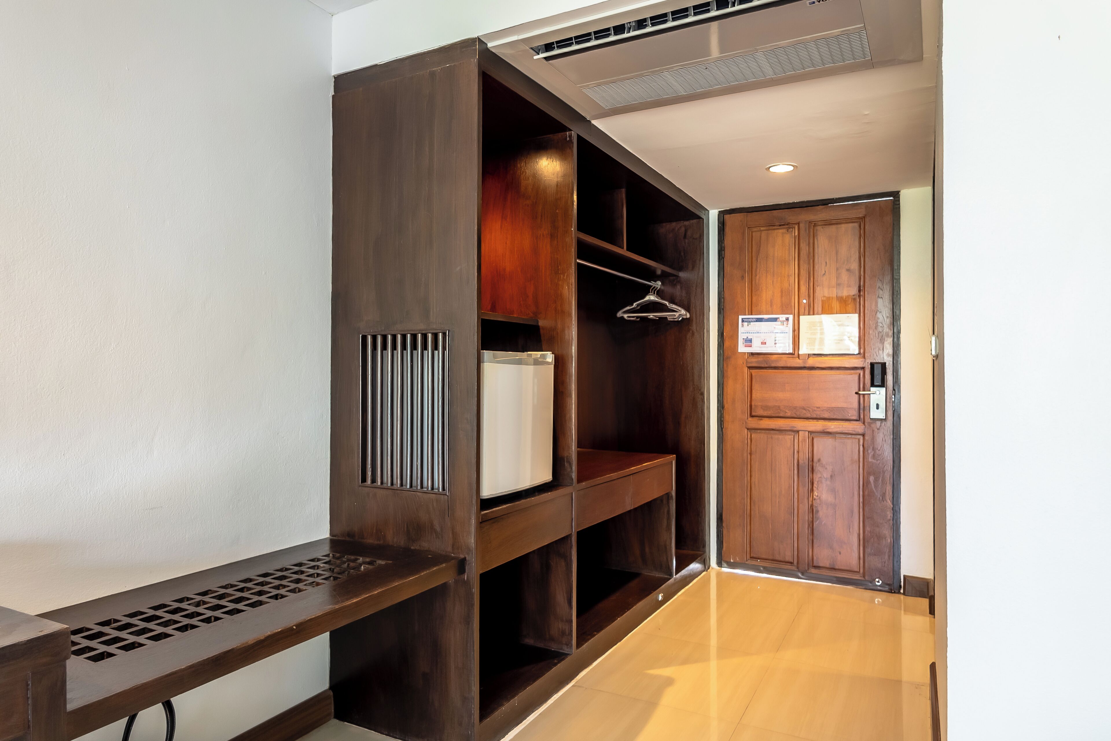 A walk-in closet with wooden shelving and a hanging rod.