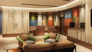 A modern lounge area with sofas, a small table, and a TV. - Citadines North Shinjuku Tokyo (Tokyo)