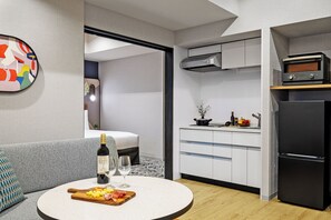 A modern kitchen with a refrigerator, oven, and microwave.