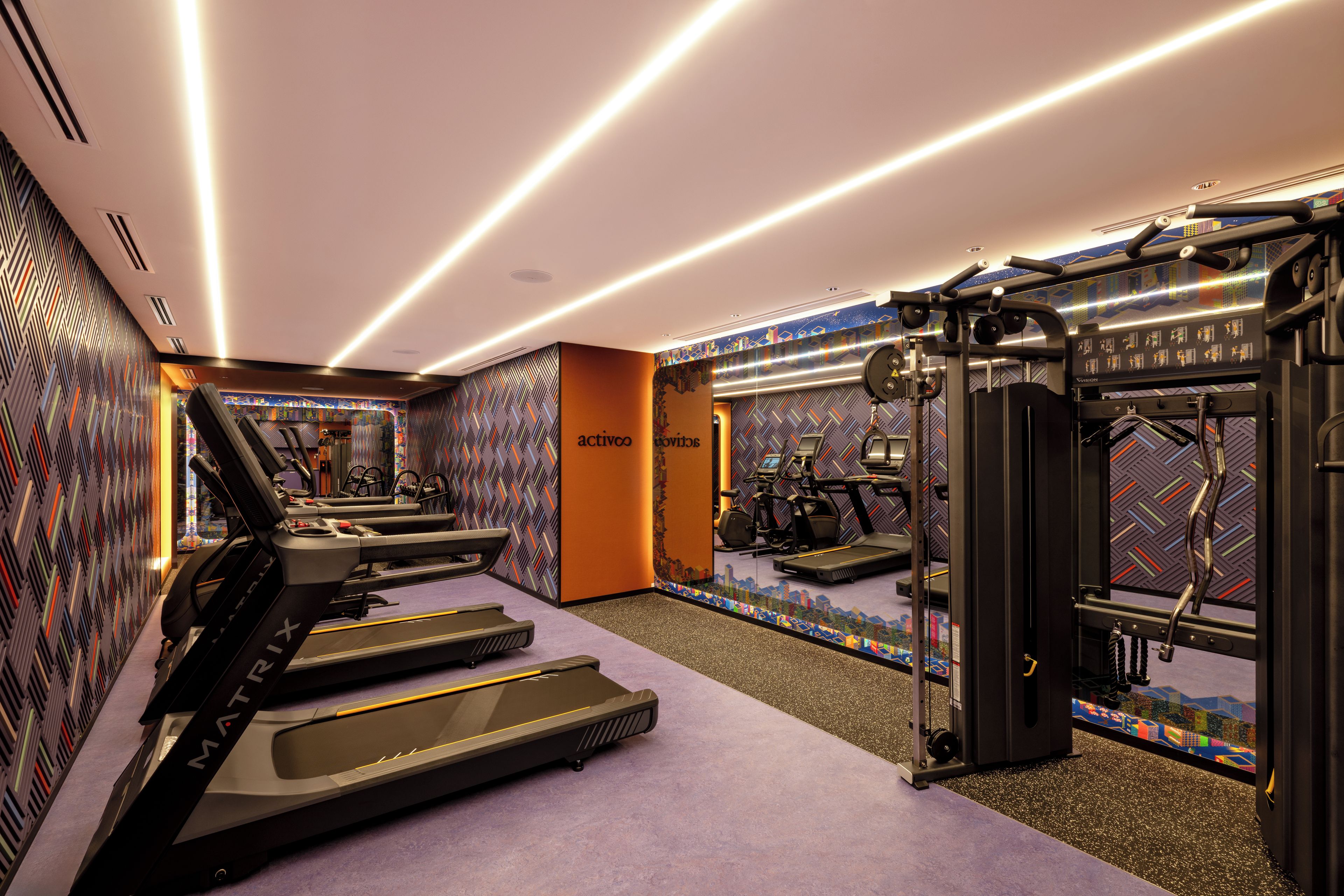 A gym with treadmills, exercise bikes, and weight machines.